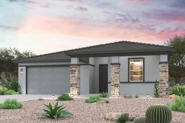 prairie-style house featuring a garage, stone siding, concrete driveway, and stucco siding