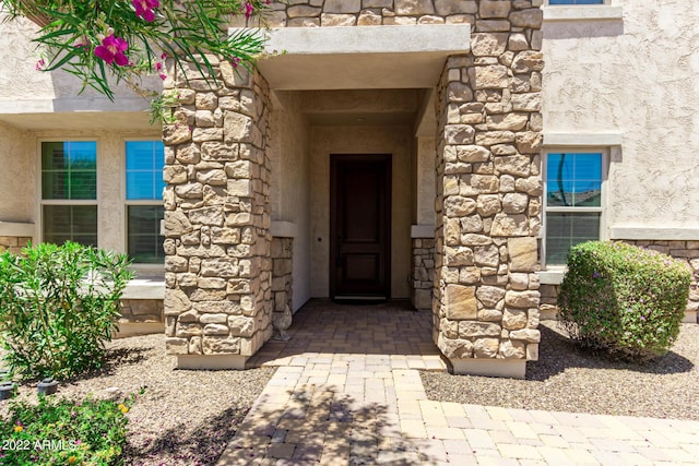 property entrance with stone siding and stucco siding