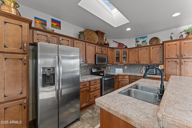 3874 Pura Vida Trl, Wickenburg, AZ 85390 - kitchen with a sink, brown cabinetry, a skylight, and appliances with stainless steel finishes