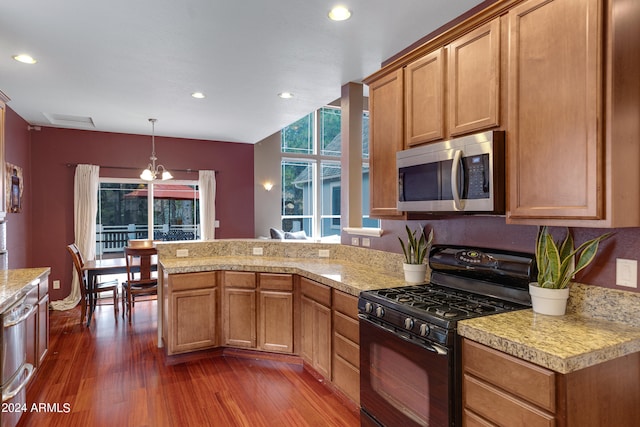 kitchen with appliances with stainless steel finishes, hanging light fixtures, a chandelier, and dark hardwood / wood-style flooring