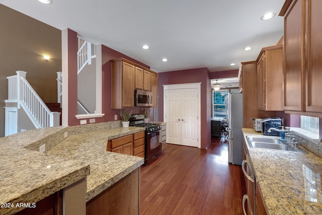 kitchen featuring light stone counters, appliances with stainless steel finishes, dark hardwood / wood-style floors, and sink