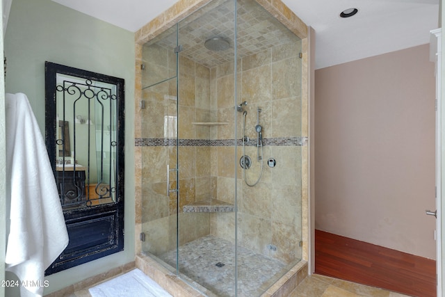 bathroom with hardwood / wood-style flooring and an enclosed shower