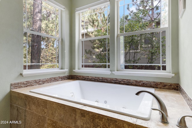 bathroom with a relaxing tiled tub and a wealth of natural light