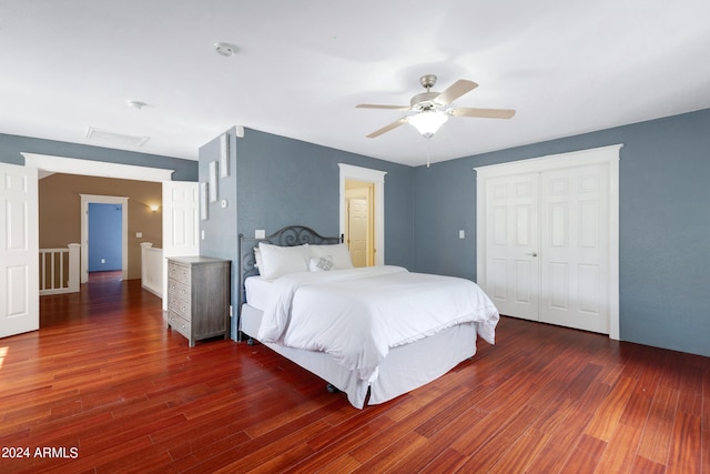 bedroom featuring dark wood-type flooring, a closet, and ceiling fan