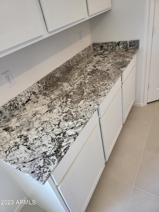 details featuring white cabinetry and dark stone counters