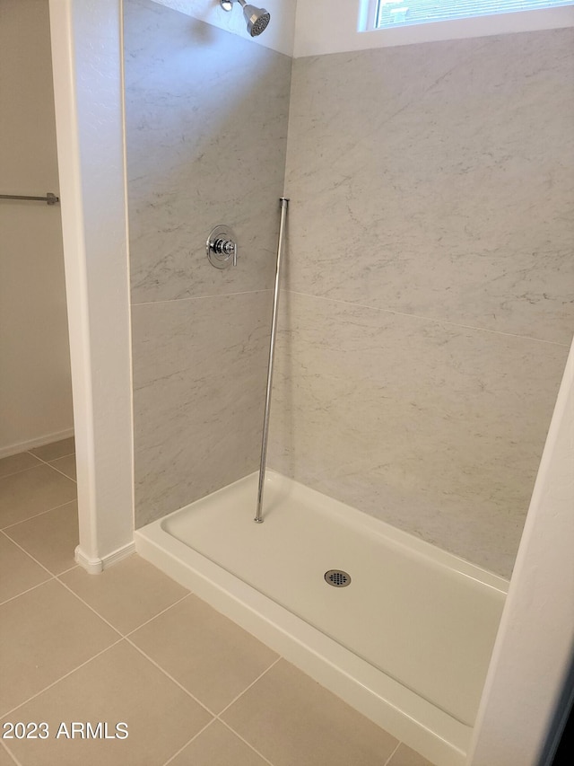 bathroom with tile patterned floors and tiled shower