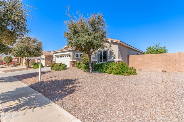 view of front of house featuring a tiled roof, an attached garage, fence, and stucco siding