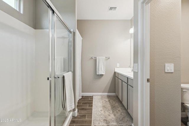 1281 W Highland Rd, San Tan Valley, AZ 85143 - bathroom with wood finish floors, a shower stall, vanity, toilet, and baseboards