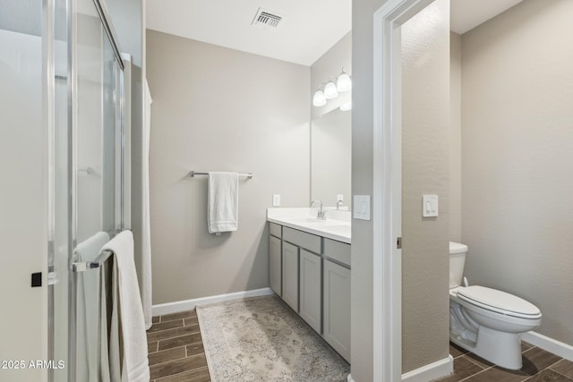 1281 W Highland Rd, San Tan Valley, AZ 85143 - bathroom with wood tiled floors, vanity, toilet, and an enclosed shower