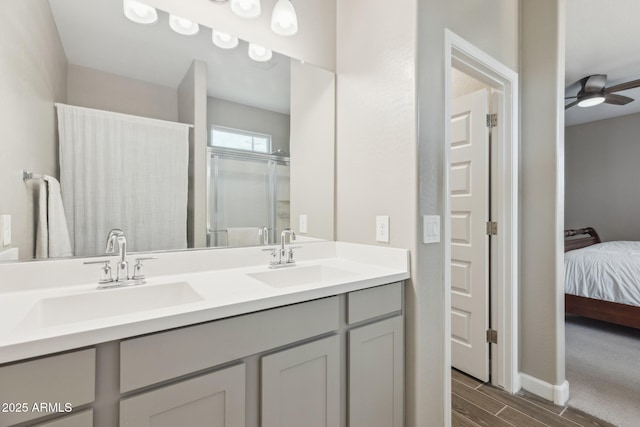 1281 W Highland Rd, San Tan Valley, AZ 85143 - ensuite bathroom featuring double vanity, wood finish floors, ceiling fan, baseboards, and a shower with door