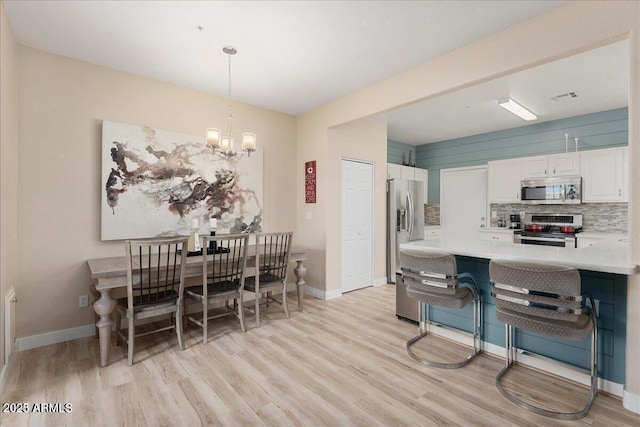 dining room featuring an inviting chandelier and light hardwood / wood-style floors