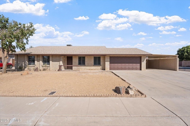 single story home featuring a garage, driveway, brick siding, and roof with shingles