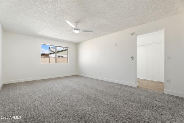 empty room with a ceiling fan, carpet, a textured ceiling, and baseboards