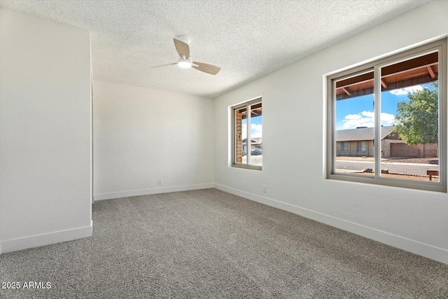 unfurnished room featuring carpet, baseboards, ceiling fan, and a textured ceiling