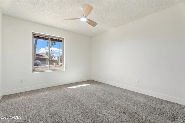 carpeted empty room with ceiling fan, a textured ceiling, and baseboards