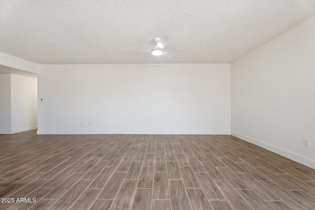 empty room featuring ceiling fan, a textured ceiling, baseboards, and wood finished floors