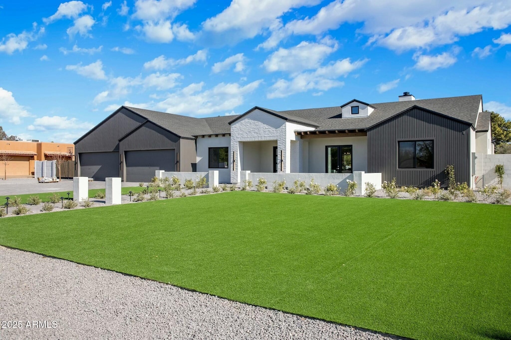 modern farmhouse style home featuring a garage and a front lawn