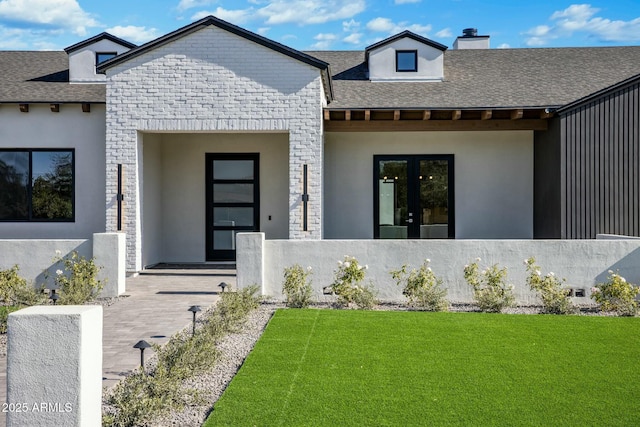 doorway to property with french doors and a lawn