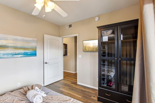 bedroom featuring dark wood-style floors, baseboards, visible vents, and ceiling fan