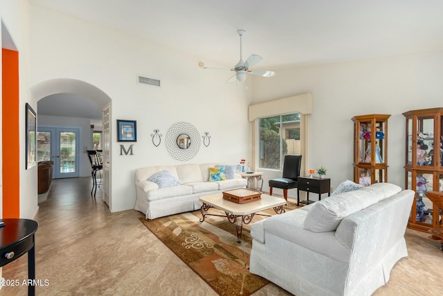 living room featuring ceiling fan, french doors, and a towering ceiling