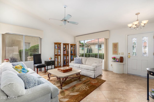 living room with a wealth of natural light, light tile patterned floors, ceiling fan with notable chandelier, and lofted ceiling