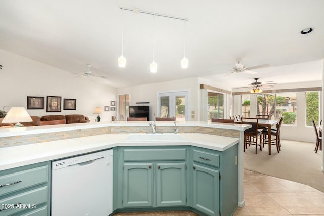 kitchen with dishwasher, sink, hanging light fixtures, green cabinets, and light tile patterned floors