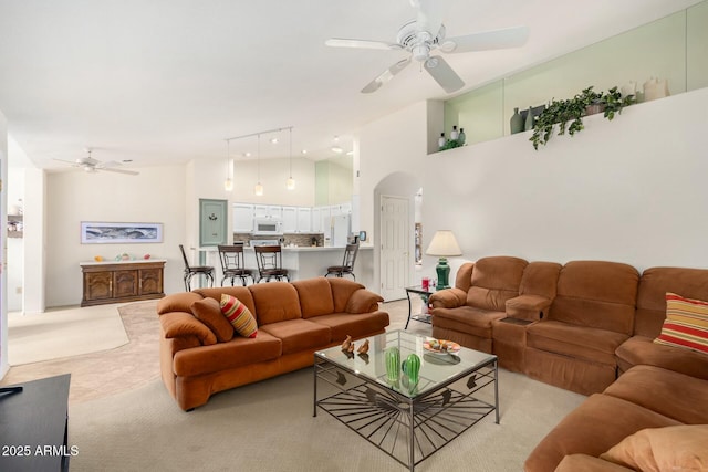 living room featuring ceiling fan and a high ceiling