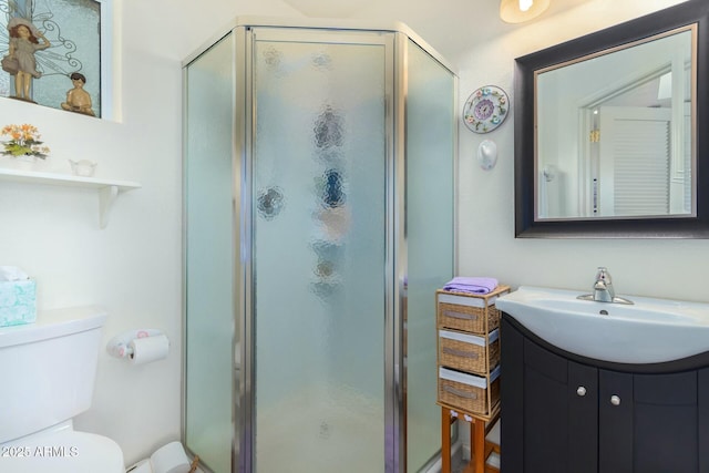 bathroom featuring vanity, toilet, and a shower with door