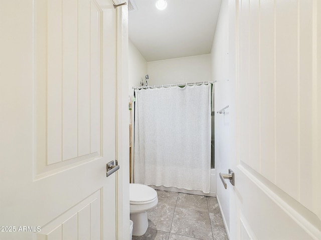 bathroom featuring shower / bathtub combination with curtain, tile patterned floors, and toilet