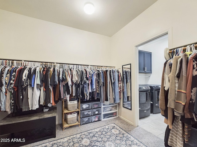 walk in closet with light carpet and washer and clothes dryer