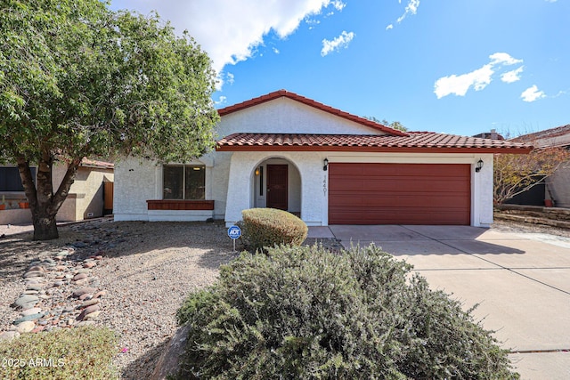 mediterranean / spanish home with a tile roof, an attached garage, driveway, and stucco siding