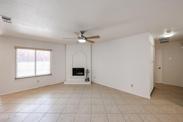 unfurnished living room featuring light tile patterned floors, a fireplace, visible vents, and ceiling fan