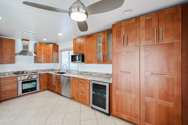 kitchen with a sink, stainless steel appliances, wine cooler, wall chimney exhaust hood, and brown cabinets