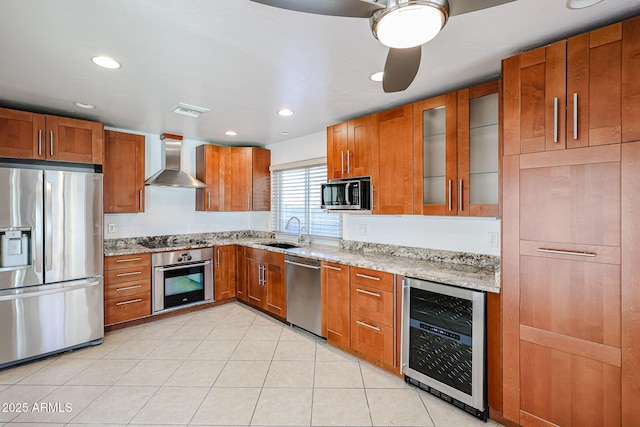 kitchen with wine cooler, brown cabinets, stainless steel appliances, wall chimney exhaust hood, and a sink