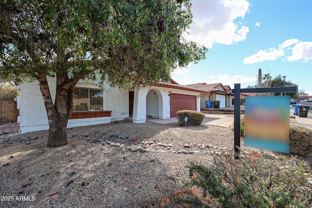 view of front facade featuring stucco siding, concrete driveway, an attached garage, and a tile roof