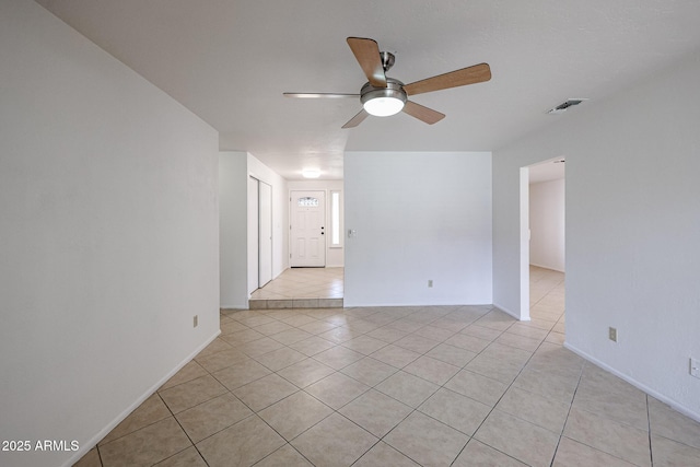 spare room featuring light tile patterned floors, visible vents, and a ceiling fan