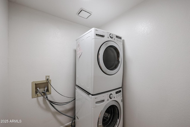 laundry area featuring stacked washer and clothes dryer and laundry area