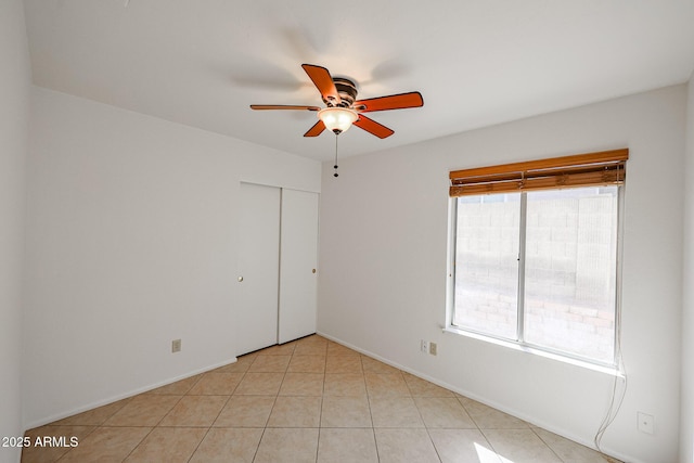 empty room with light tile patterned floors and ceiling fan