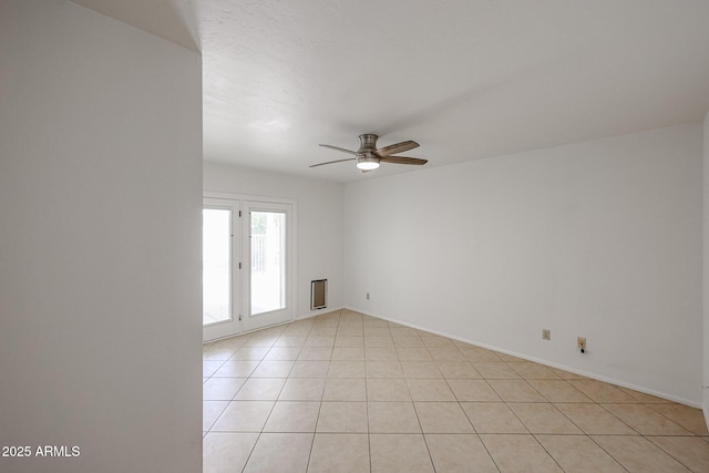 spare room featuring baseboards, light tile patterned flooring, and a ceiling fan