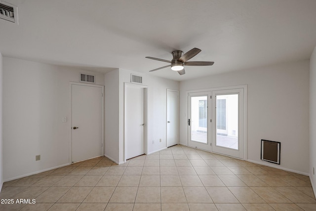 spare room with light tile patterned floors, a ceiling fan, and visible vents