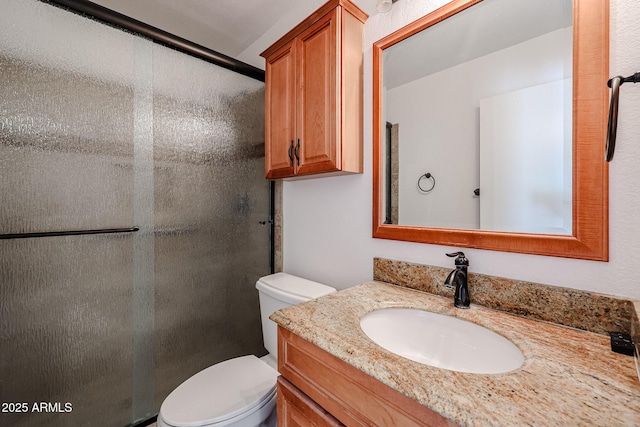 full bath with vanity, toilet, and a stall shower