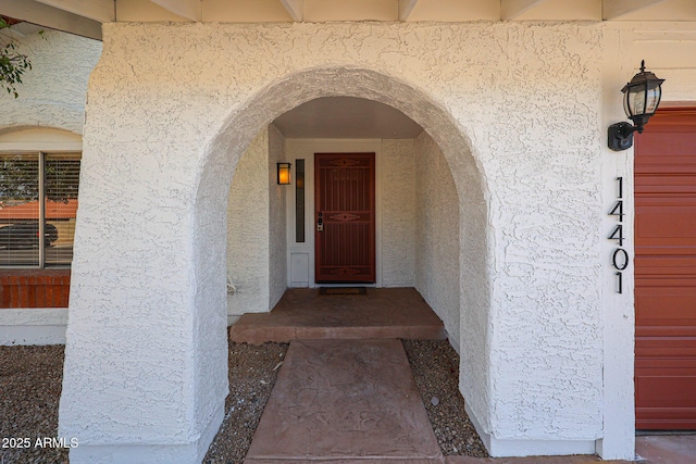 entrance to property featuring stucco siding