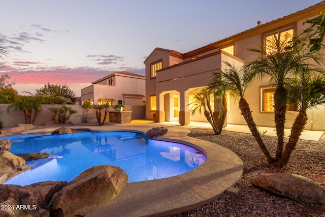 pool at dusk featuring a patio