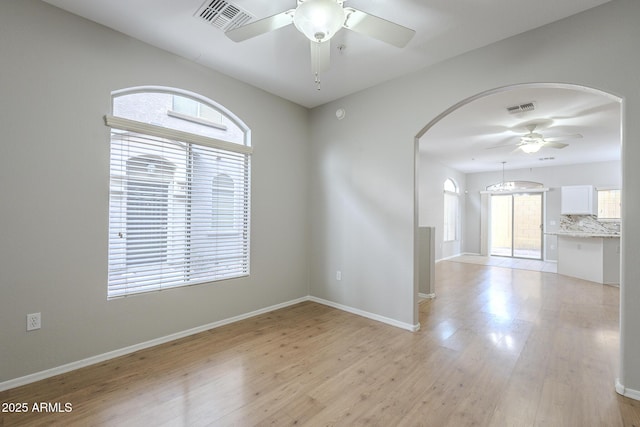 spare room with light wood-type flooring and ceiling fan