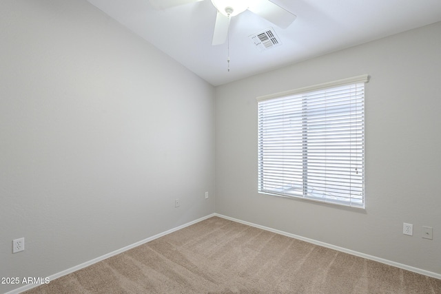 carpeted spare room featuring ceiling fan and plenty of natural light