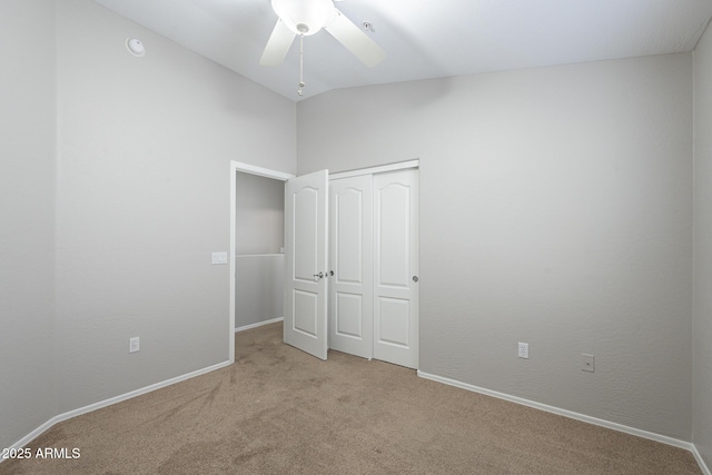 unfurnished bedroom with ceiling fan, light colored carpet, lofted ceiling, and a closet