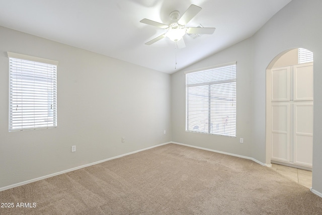 empty room with ceiling fan, light colored carpet, and lofted ceiling