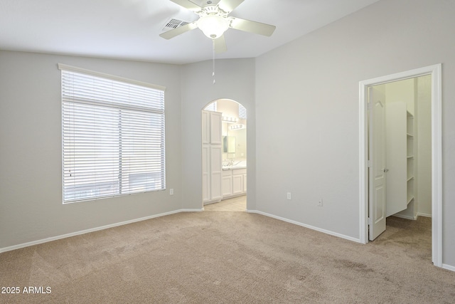 empty room with ceiling fan, sink, light colored carpet, and lofted ceiling