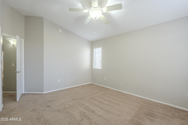 spare room with ceiling fan, light colored carpet, and vaulted ceiling