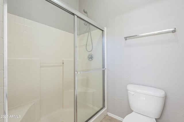 bathroom with toilet and an enclosed shower